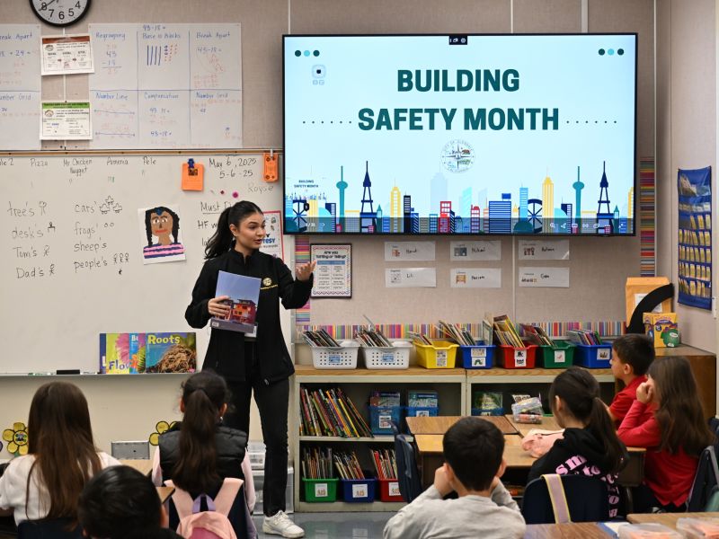 Senior Permit Services Technician Lea Issagholian speaks about building safety to a group of second grade students at a local elementary school in 2025.