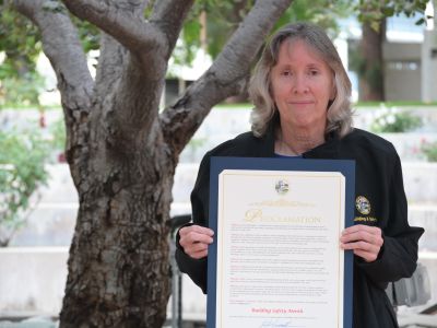 Woman holding proclamation next to a tree
